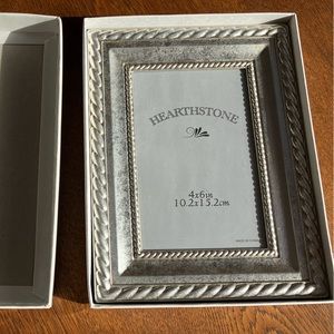 NEW still in box, outside 6x8,inside 4x6 opening. pretty silvertone braid edge.